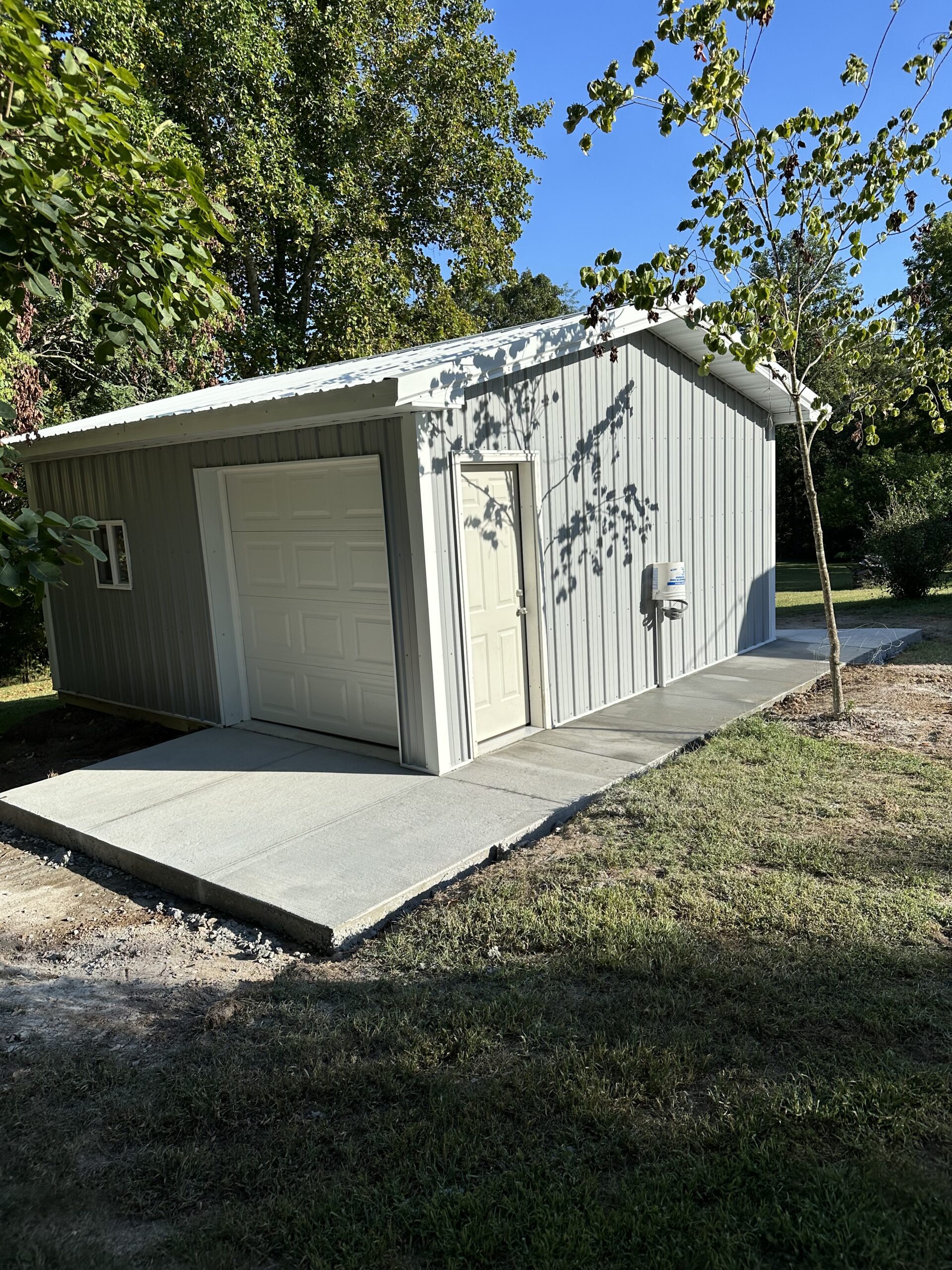 Small outbuilding structure with framing and concrete sidewalk by Williams Construction
